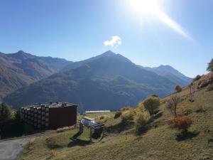une montagne au loin avec un bâtiment sur une colline dans l'établissement Studio cabine 24 m², 4 pers, près télésiège - FR-1-636-95, à Orcières 2 autres photos