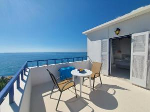a balcony with a table and chairs and the ocean at Hotel Agia Roumeli by the SEA in Agia Roumeli