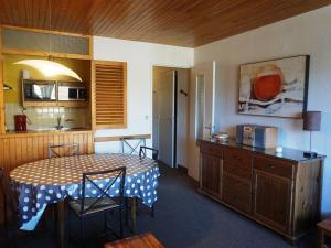 a dining room with a table and a kitchen at 3 pièces 60m², 8 pers, proche pistes, animaux acceptés - FR-1-636-119 in Orcières