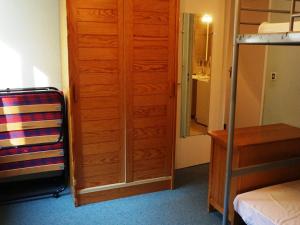 a bedroom with a wooden cabinet next to a bed at 3 pièces 60m², 8 pers, proche pistes, animaux acceptés - FR-1-636-119 in Orcières