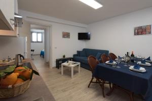 un soggiorno con 2 tavoli e un divano blu di I Tre Golfi - Via Salvatore Quasimodo a San Vito lo Capo