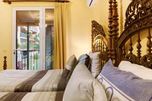 Un dormitorio con una gran cama de madera con almohadas en Palheiro Residence Vista Mar, en Funchal