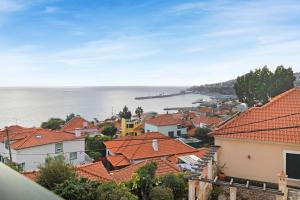 vistas a una ciudad con techos naranjas en Palheiro Residence Vista Mar, en Funchal