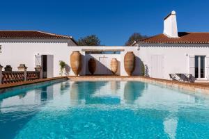 a swimming pool in front of a house at Cenoura-Brava in Évora