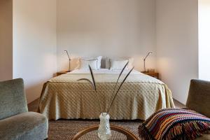 a bedroom with a bed with a vase on a table at Quinta do Santo - Évora in Évora