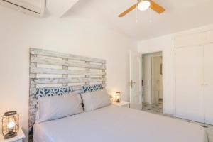 - une chambre avec un lit blanc et une tête de lit en bois dans l'établissement Piso de 2 Dormitorios Playa Bajadilla Marbella Centro, à Marbella