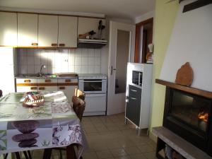 - une cuisine avec une table et une cheminée dans l'établissement Gîte Les Hirondelles, à Plombières-les-Bains