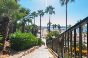 un escalier menant à la plage avec des palmiers. dans l'établissement Piso de 2 Dormitorios Playa Bajadilla Marbella Centro, à Marbella