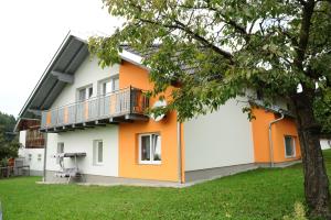 uma casa laranja e branca com uma varanda em Frühstückspension Lach em Eberndorf