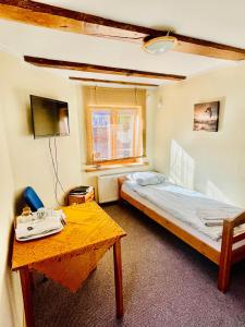 a small room with a bed and a table at Express Guest House in Klaipėda