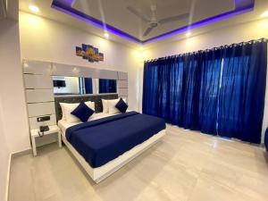 1 dormitorio con 1 cama grande y cortinas azules en The Metro Stay By F9 Hotels-Near Sector 18 Metro Station Noida en Noida