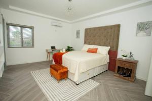 ein weißes Schlafzimmer mit einem Bett und einem Tisch in der Unterkunft FunTime Vacation Home in Kingston