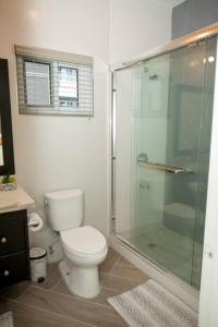 a bathroom with a toilet and a glass shower at FunTime Vacation Home in Kingston