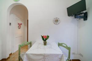 a dining room table with a vase of flowers on it at Dimora Capoliveri in Capoliveri
