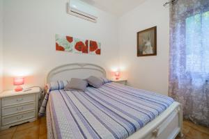 a bedroom with a bed with two lamps and a window at Dimora Capoliveri in Capoliveri