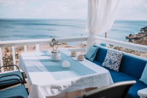 a blue couch and a table with a view of the ocean at Villa Sea Breeze in Karpathos