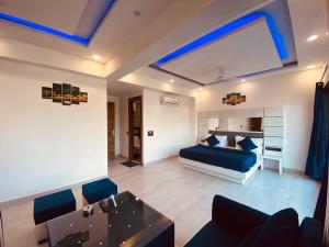 1 dormitorio con cama, sofá y TV en The Metro Stay By F9 Hotels-Near Sector 18 Metro Station Noida, en Noida