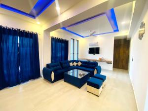 een woonkamer met een blauwe bank en een tafel bij The Metro Stay By F9 Hotels-Near Sector 18 Metro Station Noida in Noida