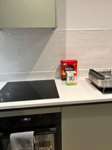 a kitchen with a counter with a stove top oven at Lovely Super Luxury One Bed Apartment 216 in Luton