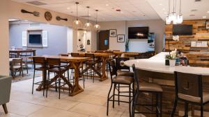 uma sala de jantar com mesas e cadeiras num restaurante em Holiday Inn Greenville, an IHG Hotel em Greenville