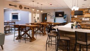 a dining room with tables and chairs in a restaurant at Holiday Inn Greenville by IHG in Greenville