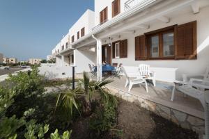Casa blanca con patio con mesa y sillas en I Tre Golfi - Via Salvatore Quasimodo en San Vito lo Capo