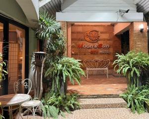 a patio with a bench in front of a building at โรงแรมมูนแอนด์ซัน Moon and Sun Hotel in Chiang Rai