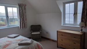 um quarto com uma cama, uma cadeira e janelas em Bunloyne em Sallachy mais 37 fotografias