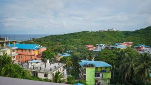 a group of buildings on a hill next to the ocean at Hills And Sea View in Port Blair