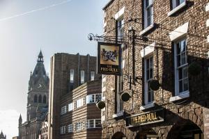 een bord voor een pub aan de zijkant van een gebouw bij The Pied Bull in Chester