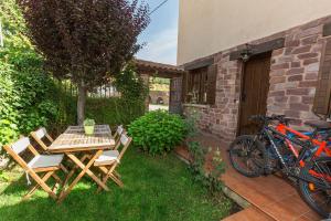 un patio con mesa, sillas y bicicleta en Casa Fresneda, en Fresneda de la Sierra Tirón