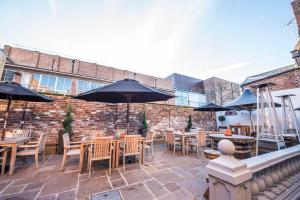 a patio with tables and chairs with umbrellas at The Pied Bull in Chester