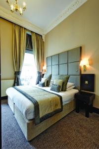 a hotel room with a large bed and two lamps at Grange White Hall Hotel in London