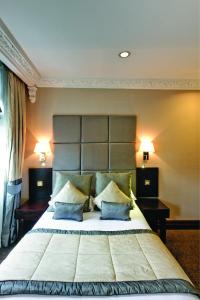 a bedroom with a large bed and a large mirror at Grange White Hall Hotel in London