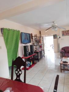 sala de estar con sofá y ventilador de techo en Tina's Guest House, en Ocho Ríos