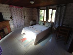 a bedroom with a bed in a room with windows at Pousada Da Santina in Visconde De Maua
