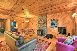 a living room with a couch and a fireplace at Cozy Maggie Valley Cabin with Deck and Private Hot Tub in Maggie Valley