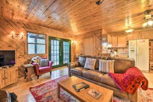 a living room with a couch and a table at Cozy Maggie Valley Cabin with Deck and Private Hot Tub in Maggie Valley
