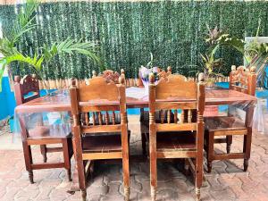 een houten tafel met 2 stoelen en een houten tafel met een hek bij Tumben Kuxtal Tulum in Tulum