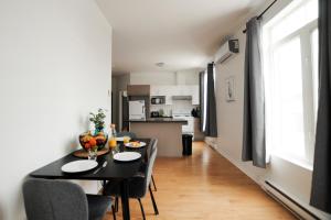 a dining room and kitchen with a table and chairs at Le 1808 - Spacieux avec Balcon - Nord de Québec in Quebec City