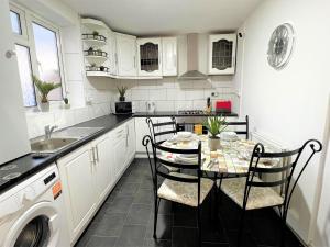 a kitchen with a table and chairs and a sink at Stepney Green Comfy Double bed rooms 14 in London