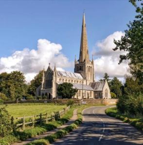 a large church with a steeple and a road at York Cottage a period character 2 bedroom cottage in Snettisham