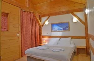a bedroom with a bed in a wooden cabin at Appartement dans chalet 5 chambres 130 m2 centre village in Montriond