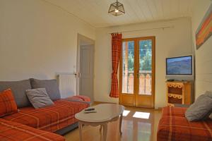 een woonkamer met een bank en een tafel bij Appartement dans chalet 5 chambres 130 m2 centre village in Montriond