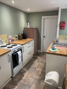 a kitchen with a stove and a sink at York Cottage a period character 2 bedroom cottage in Snettisham