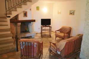 salon z kanapą, telewizorem i schodami w obiekcie Borgo Le Logge w mieście Budoni