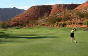 uma mulher está a jogar golfe num campo de golfe em Hawk Ridge Two Bedroom Condo by Cool Properties em Mesquite