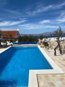 een groot blauw zwembad voor een huis bij Villa Maslina in Sutivan