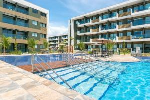 a swimming pool in front of a building at Mana Beach Experience Muro Alto por Brevelar in Porto De Galinhas