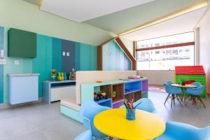 ein Kinderzimmer mit einem gelben Tisch und blauen Stühlen in der Unterkunft Mana Beach Experience Muro Alto por Brevelar in Porto De Galinhas